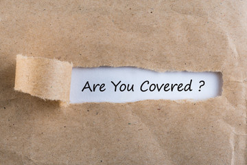 ARE YOU COVERED? Question message appearing behind ripped brown paper. Are you insured for your...