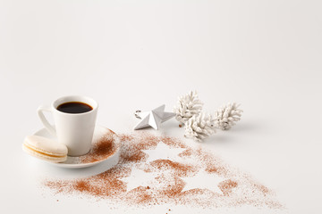 One small cup of cofee and cocoa powder on white table