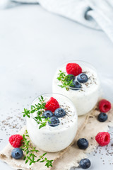 Healthy vegan white chia pudding with berries and green thyme