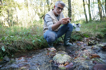 Biologist testing water quality of river