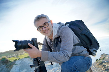 Portrait of photographer taking pictures in natural landscape - Powered by Adobe