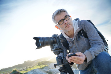 Obraz premium Photographer using wifi device to look at photo shots