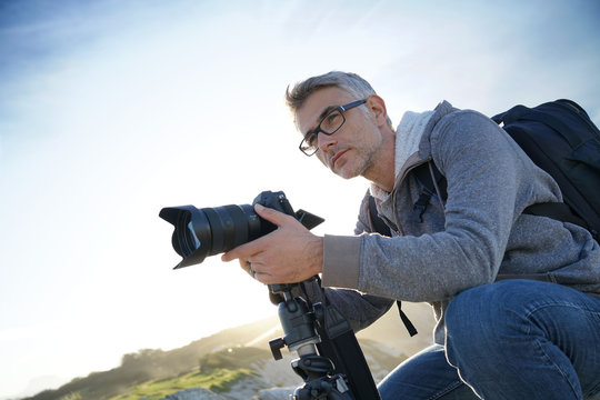 Portrait of photographer taking pictures in natural landscape