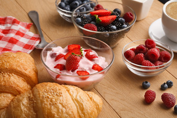 Continental breakfast with croissants and berries on natural wood