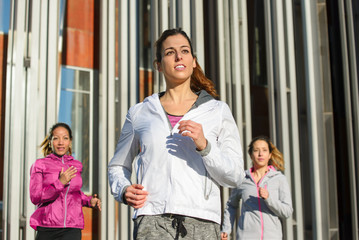 Group of sporty women running. Female urban athetes training outside.