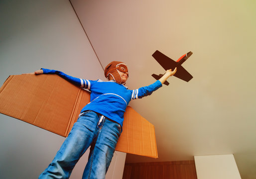little boy with pilot glasses and wings play fly at home