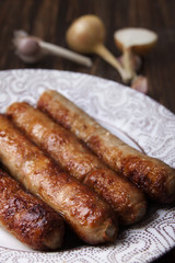 Meat sausages with garlic and onions in a plate