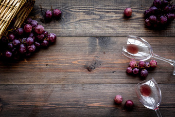 Glass with wine sediment and grape on dark wooden background top view copyspace