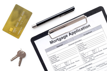 Mortgage application near bank card and apartment keys on white background top view