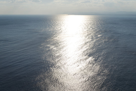 The sun over the sea. The island of Crete, the mountains.