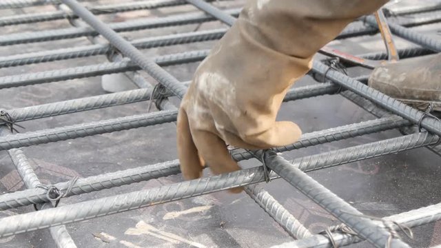 worker preparing bundle wire on steel bar in construction site