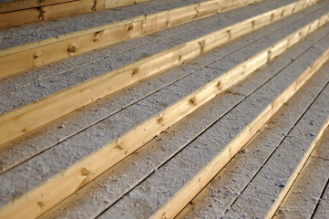 wooden stairs covered with snow lit by sunrise