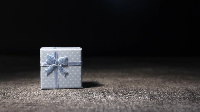 Gift present box mooving on black stage background