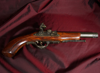 An old fake gun on a bright cloth.