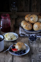 Homemade buns with linseed sunflower seeds for breakfast with butter and blueberry jam