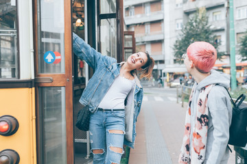 two young women outdoors getting off tram