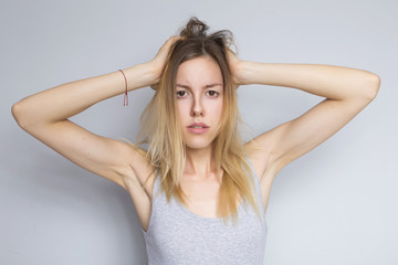 Fototapeta premium Piękna brunetka kaukaski kobieta w szarej bluzce z jasnymi emocjami stojąc na neutralnym szarym tle. Jej ręce wykonują gest. Zachowuje się seksownie, uwodzicielsko