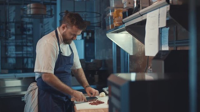Man cutting meat in the kitchen