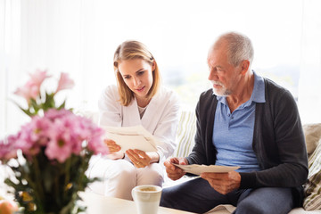 Health visitor and a senior man during home visit.