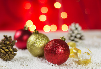 Christmas baubles on snow. With golden lights and the gir