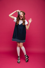 Full-length shot of shocked lady making photo with retro camera