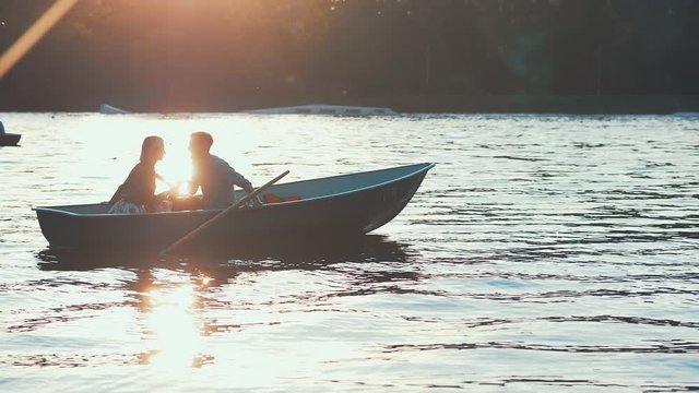 Kissing couple in a boat at sunset