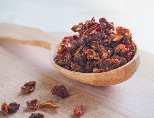 Spice dried tomato and wooden spoon on a wooden table.
