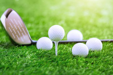 Golf club and ball on green grass