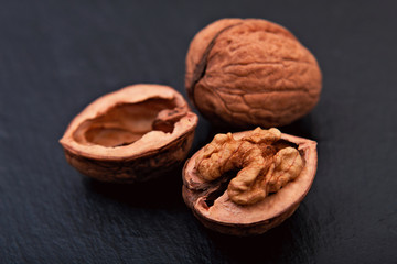 Healthy food concept Spot focus natural walnuts kernel on black slate stone background with copy space