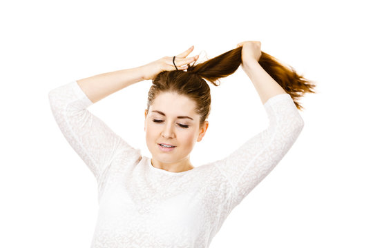 Young woman touching her long brown hair