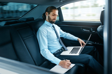 Portrait Of Business Man Working On Notebook, Traveling In Car.