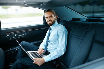 Portrait Of Business Man Working On Notebook, Traveling In Car.