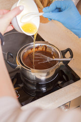 Woman preparing homemade no sugar proper nutrition chocolate candies on a wooden background. Healthy food