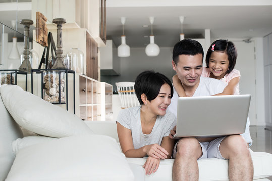 Young Asian family using the computer together at home.