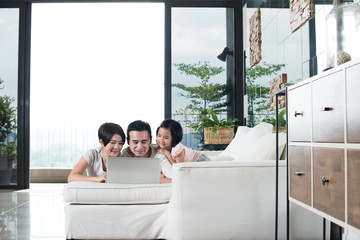Young Asian family using the computer together at home.