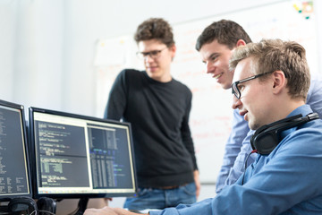 Startup business and entrepreneurship. Young software developers team brainstorming and programming...