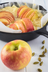 Unbaked cardamom cognac apple cake in iron skillet.