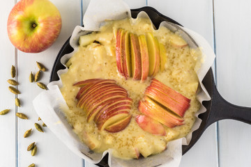 Unbaked cardamom cognac apple cake in iron skillet.