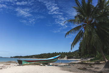 Fototapeta na wymiar tranquil tropical beach with old boat on sunny day