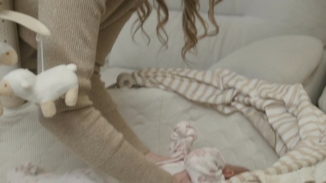 The girl takes the child out of the crib