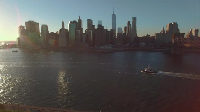 Aerial view of Manhattan, boats sailing down the river. Camera moving along the East river to the right filming the panorama of Manhattan.