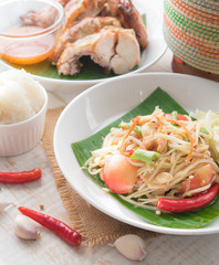 Green papaya salad,Som tum Thai and grilled chicken on wood table