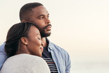 Young African couple enjoying a sunset at the beach