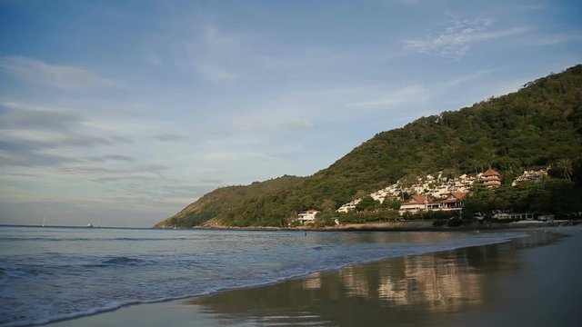 Sunny day on Nai Harn beach. View on buildings on hill. Phuket, Thailand.