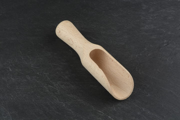 Cuchara de madera sobre plato de pizarra negra