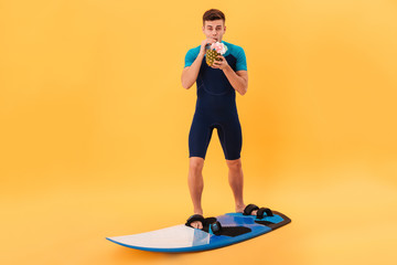Image of Smiling surfer in wetsuit using surfboard