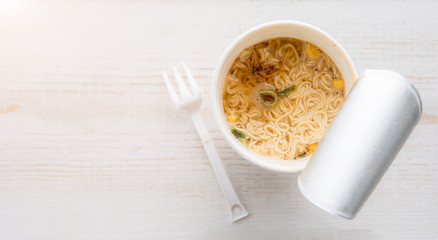 Instant noodle cup on wooden table,Top view,Selective focus on Instant noodle