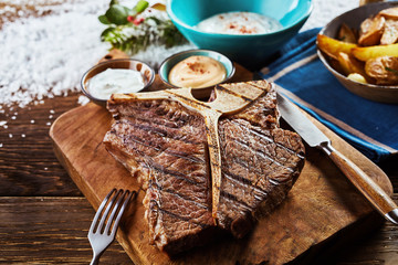 Piece of grilled t-bone steak on wooden board
