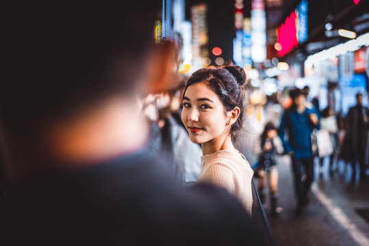 Portrait of young woman outdoors by night, Tokyo, Japan
