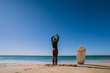 Fototapeta na wymiar Man on the beach with surfboard in Portugal warming up